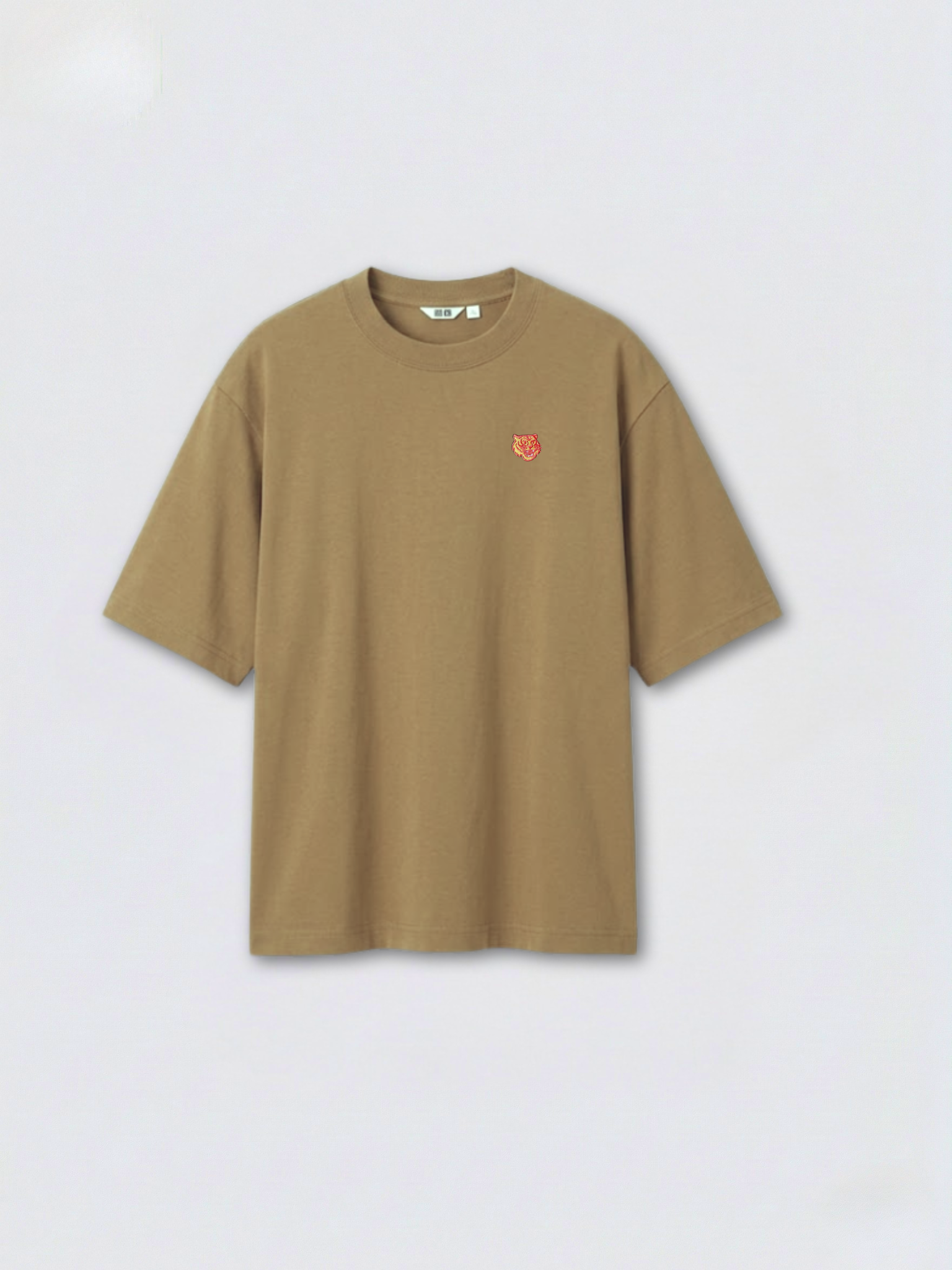 Light_brown_oversized_boxy_tee_with_1.5_inch_embroidered_tiger_face_icon_logo_by_studio_tigre_on_a_premium_uniqlo_airism_tee on a white background